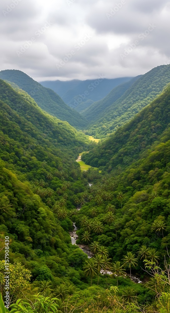 Naklejka premium Lush Green Valley with Winding Road and River Under Cloudy Sky.