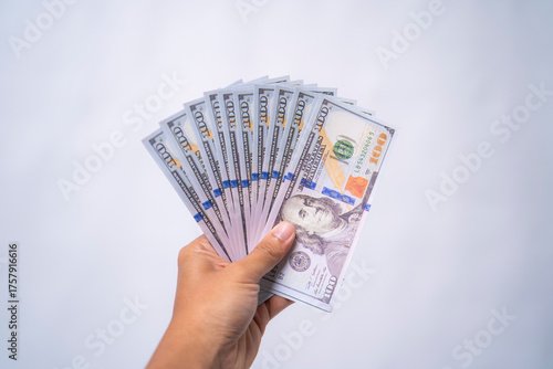 Hand holding a fan of hundred dollar bills. Payment, profit, and business concept