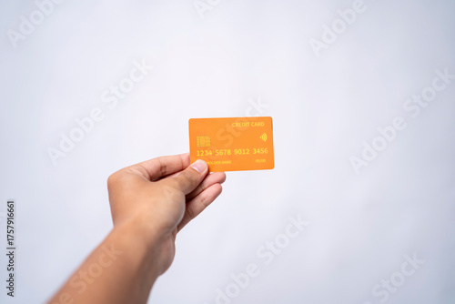 Hand holding an orange credit card