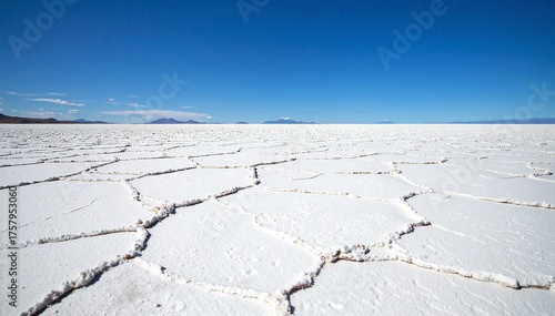 Vast, shimmering salt flats stretch across Death Valley, Nevada, reflecting the brilliant blue sky and rugged mountains, creating a stunning, otherworldly landscape.