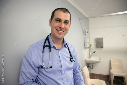 Quadro su tela Smiling male doctor standing in a medical clinic