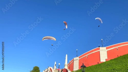 NIZHNY NOVGOROD, RUSSIA - MAY 23, 2024: Paragliders above the Chkalov Stairs. The lightweight, free-flying glider aircrafts soaring gracefully, painting the Nizhny Novgorod sky with freedom and light
