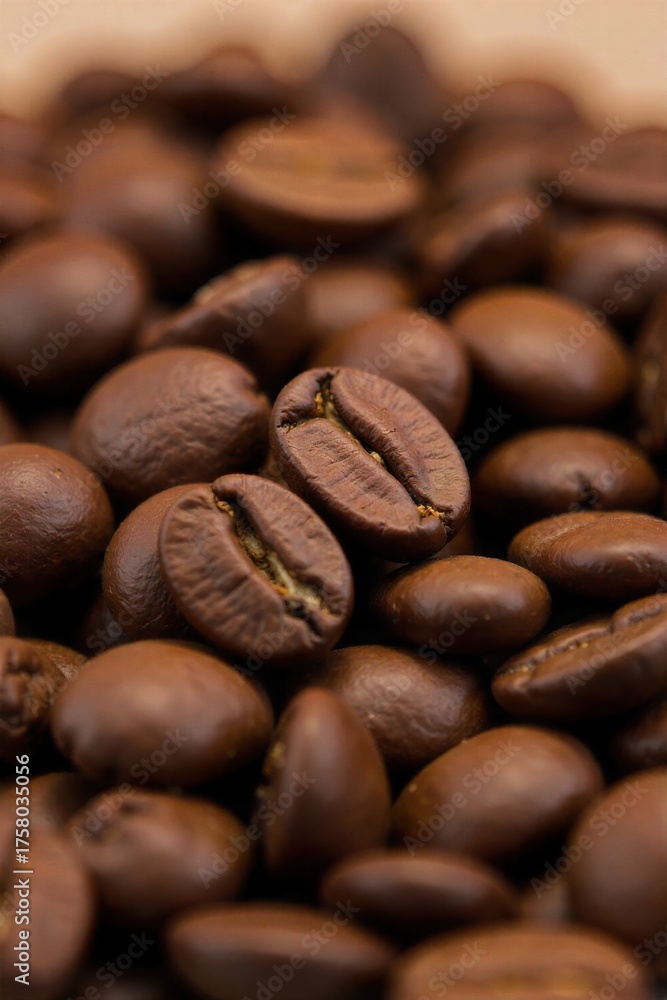 Naklejka premium Coffee Bean Roasting Process A macro shot focusing on a pile of freshly roasted coffee beans, showcasing their deep brown color, glossy sheen, and varied textures. Some beans may have a slight crackle