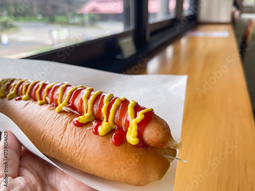 トマトケチャップとマスタードソースをトッピングしたジューシーなホットドッグ。