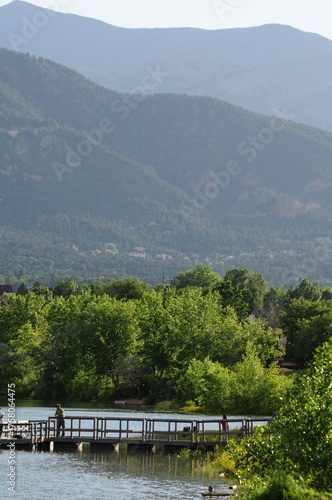 Mountain panorama with a bridge over the river in a green valley under a summer sky