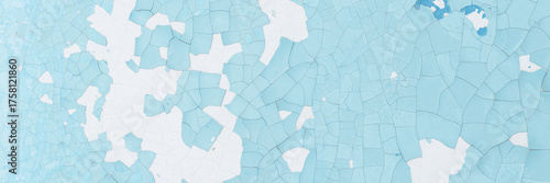 Blue peeling paint on the wall. Old concrete wall with cracked flaking paint. Weathered rough painted surface with patterns of cracks and peeling. High resolution texture for background and design.