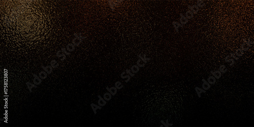 Dark textured surface with granular detail and subtle warm color variations.