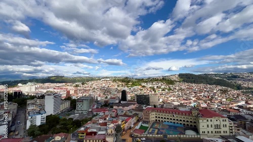 Quito, Ecuador's capital city, is sprawling under a cloudy sky with El Panecillo hill standing out in the background, creating a picturesque cityscape at sunset