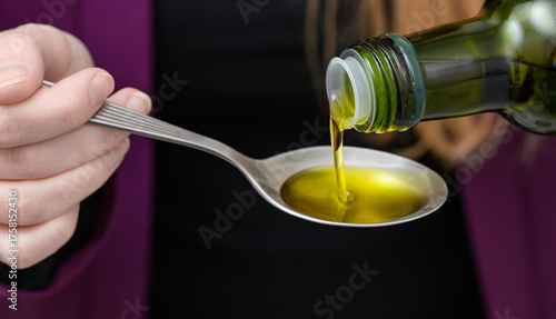 Extra virgin olive oil, naturally cloudy, poured onto a metal spoon, polyphenols