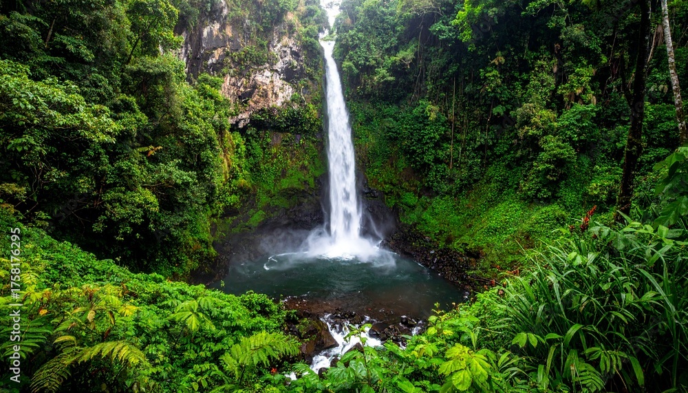 Obraz premium Waterfall cascading into a pool surrounded by lush green vegetation.