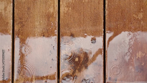 Close-Up of Wet Wooden Planks with Rain Drops Creating Ripples and Reflections in Soft Light, Texture Detail, Rainy Weather Concept