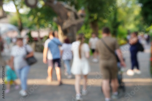Blurred background. People are walking in the city park.
