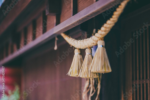 Close-up of a shimenawa sacred rope hanging on a traditional wooden building in Japan