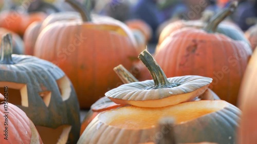 Close-up of carved pumpkins glowing in warm autumn sunlight at a local fall festival. Cozy seasonal atmosphere with vibrant colors, harvest spirit, and Halloween mood.