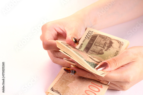 1万円札を数える女性の手