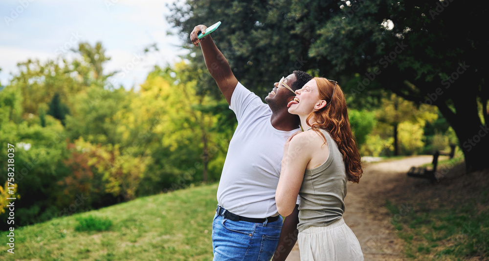 Obraz premium Young couple taking selfie and laughing together outdoors