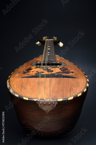 Mandolino vintage in legno su sfondo nero. Strumento musicale.