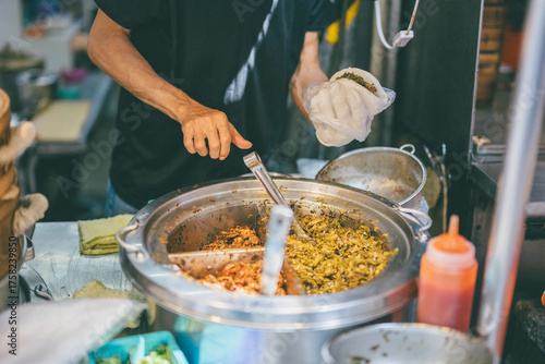 Vendor preparing Taiwanese street food at a local market stall

