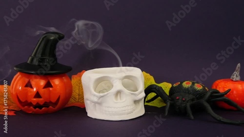 Halloween composition, blow out of a skull candle on dark purple background
