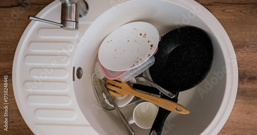 Dirty dishes pile up in the kitchen sink and then disappear. 4K looped stop motion animation