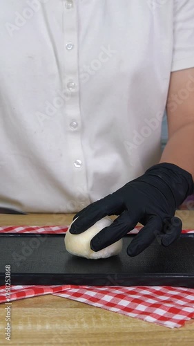 a woman cuts mochi using a knife