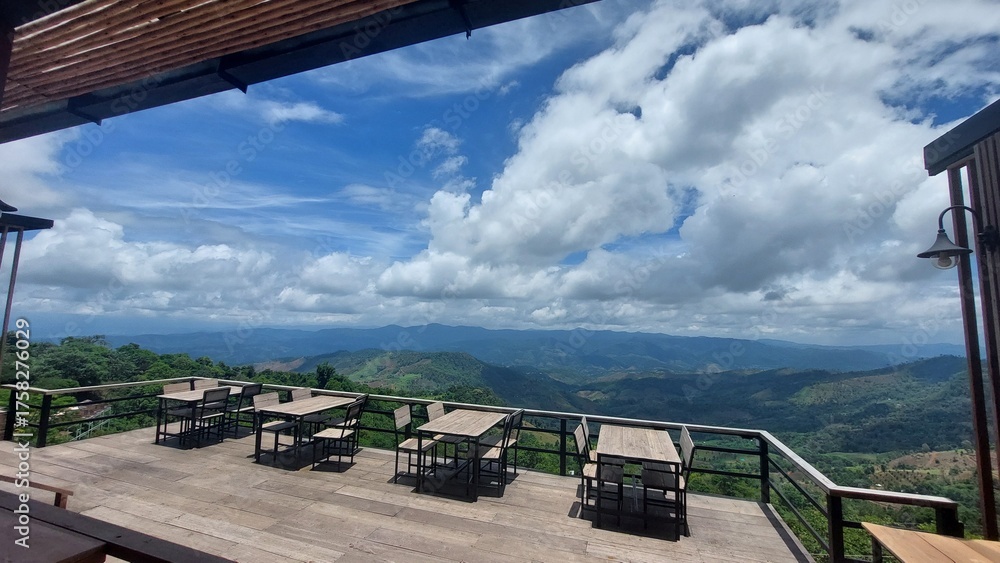 Fototapeta premium Scenic mountain view cafe with wooden tables and open terrace