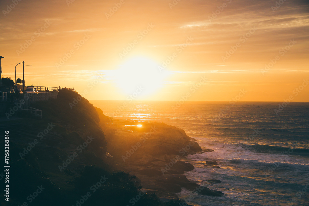 Obraz premium Golden sunrise over Bronte Beach cliffs and ocean in Sydney, Australia