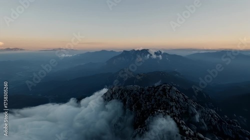 Majestic mountain range rises above a sea of clouds, in a serene landscape