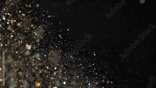 Glittering particles of varying sizes and colors against a black background