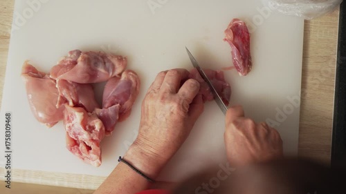 Expert chef prepares chicken for a delicious meal in a well-lit kitchen