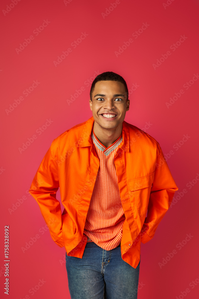 Fototapeta premium Vibrant young man expresses joy in colorful attire against bright background