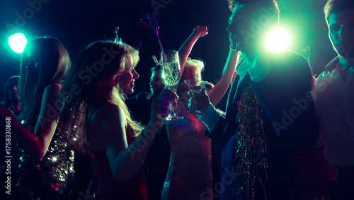 Tableau sur toile Joyful Christmas night with friends dancing and clinking glasses