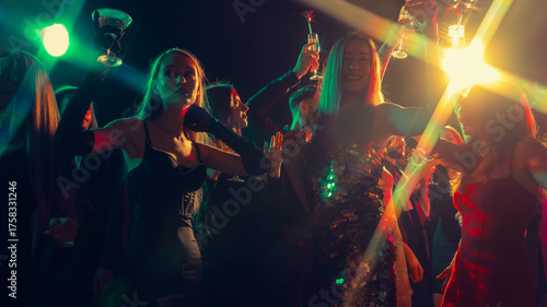 New Year Eve glamour party with people cheering in neon lights. Concept of alcohol campaign visuals, festive marketing, nightlife energy, and youth celebration