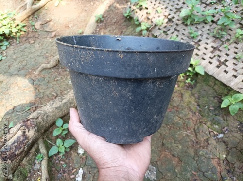 Black plastic flower pot used for planting.