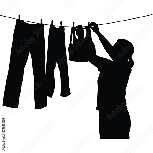 Silhouette of woman hanging clothes on a clothesline with pants and a top using clothespins
