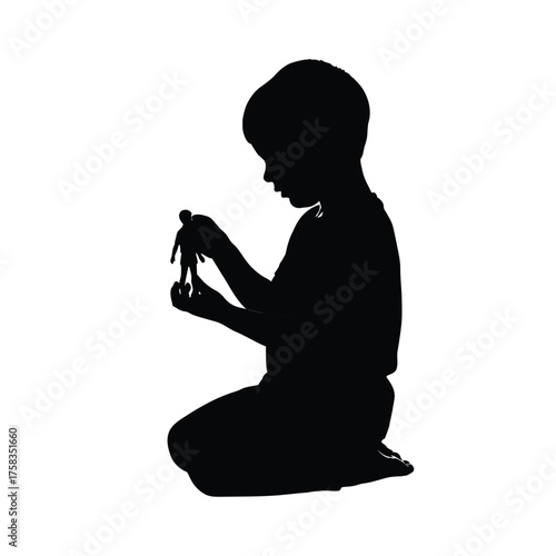 Silhouette of a child kneeling and holding a small figurine against a white background space