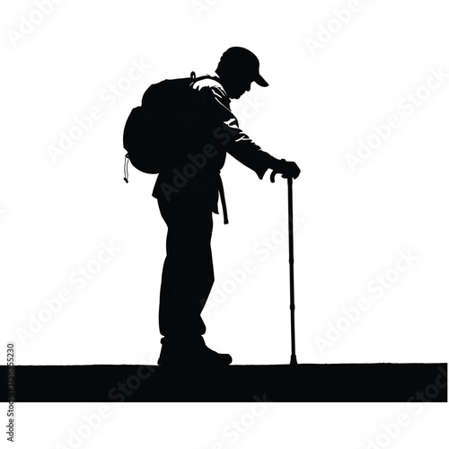 Silhouette of a man with a backpack and cane standing on a dark surface against white backdrop