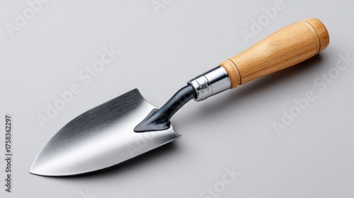 A metal and wooden-handled garden trowel, ideal for planting and digging in small areas, showcasing a sleek, functional design.