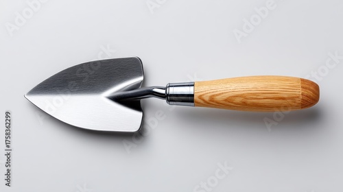 A shiny garden trowel with a wooden handle, ideal for planting and cultivating.