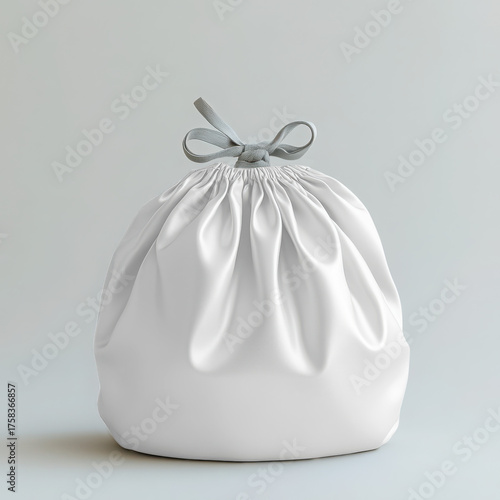 A white satin drawstring gift bag with a silver ribbon bow, isolated on a light gray background transparent mockup 