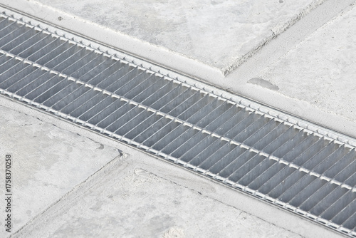 Fotografia GALVANIZED INDUSTRIAL STEEL RAINWATER COLLECTION GRATE in a parking lot with con