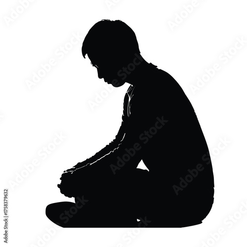Silhouette of person sitting cross legged with hands clasped looking down in contemplation pose
