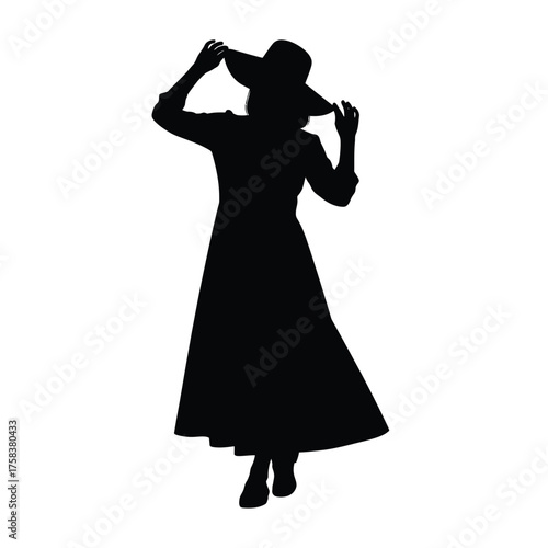 Silhouette of a woman in a long dress and wide brimmed hat adjusting the hat with her hands