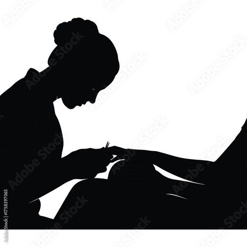 Silhouette of woman with hair bun performing manicure on client in black and white image