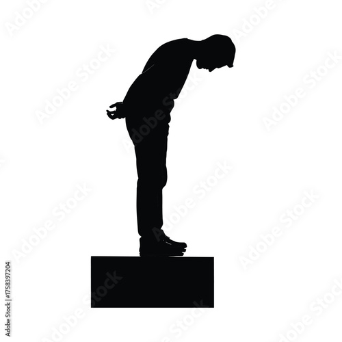 Silhouette of a person standing on a platform with their head bowed and hands behind back