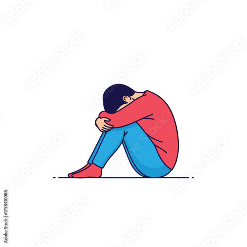 A person sits alone in a fetal position with their head bowed in sadness and despair.