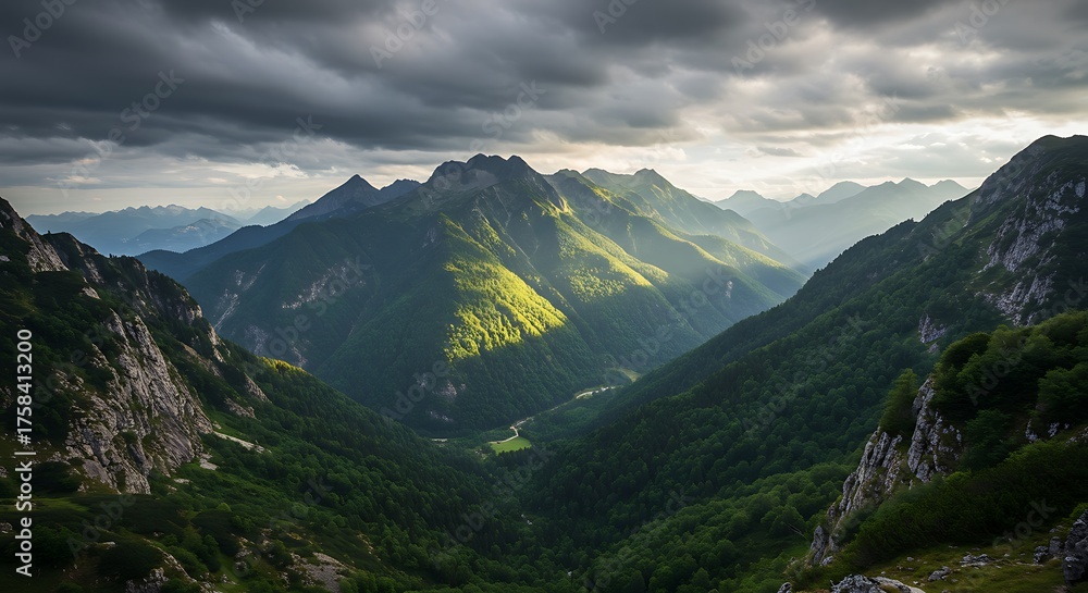 Obraz premium Dramatic mountain landscape under a stormy sky with bright sunlight illuminating peaks