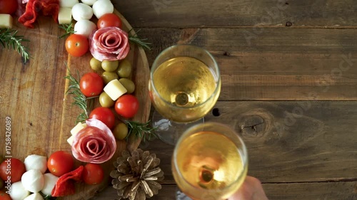 Cheese and sausage board with two glasses of wine.