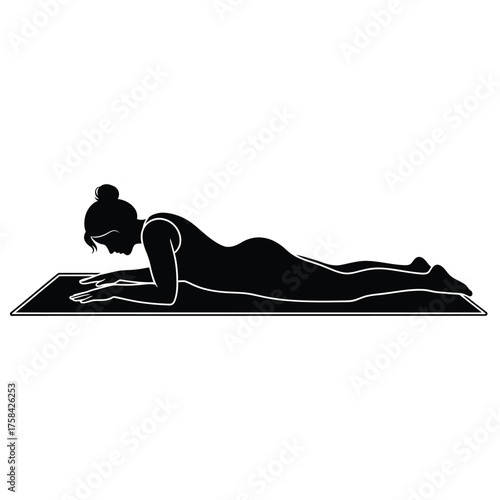 Silhouette of woman in sphinx pose on yoga mat demonstrating exercise and wellness routine