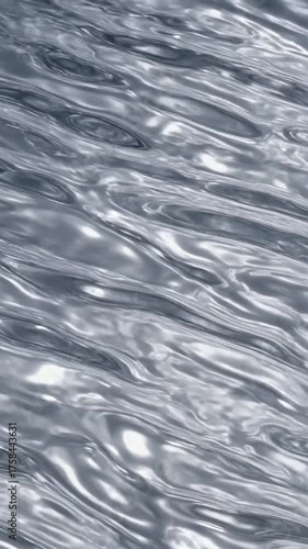 Abstract rippled fluid with a reflective metallic silver surface